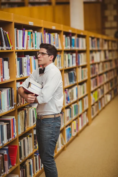 Nerd bedrijf boeken in bibliotheek — Stockfoto