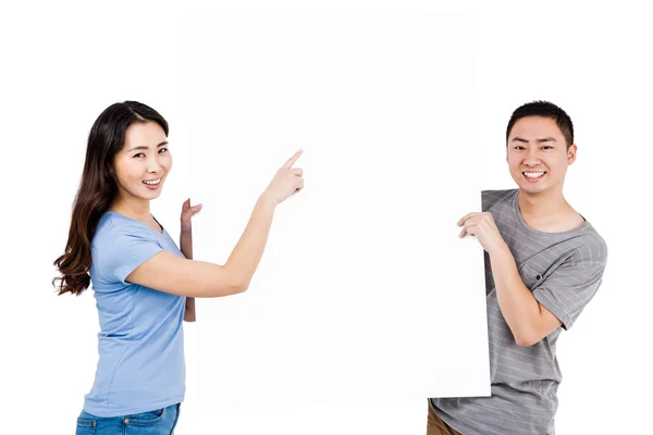 Jovem casal segurando outdoor em branco — Fotografia de Stock