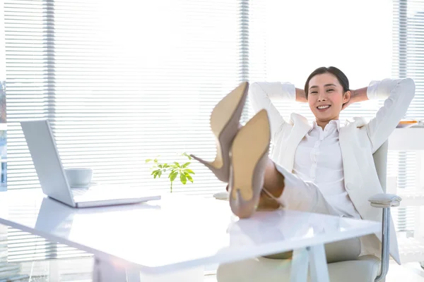 Relaxado empresária sentado com os pés para cima — Fotografia de Stock