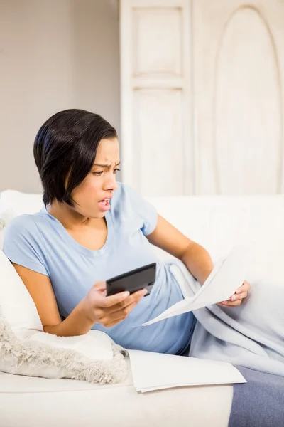 Surprised brunette counting bills — Stock Photo, Image