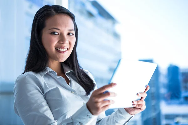 Sonriente mujer de negocios sosteniendo tableta — Foto de Stock