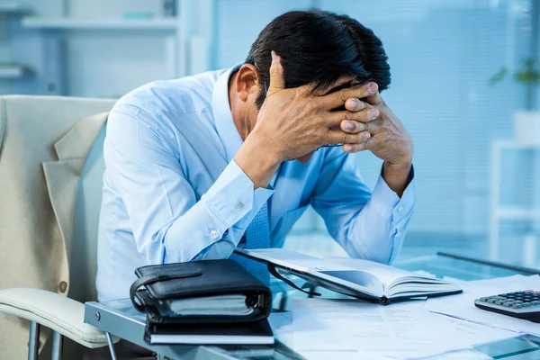 Hombre de negocios preocupado trabajando en su escritorio — Foto de Stock