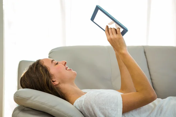 Szczęśliwa kobieta za pomocą tabletu na kanapie — Zdjęcie stockowe