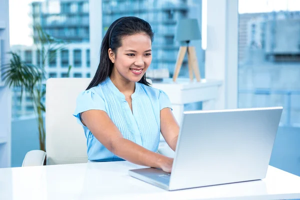 Smiling businesswoman using laptop — Stock Photo, Image