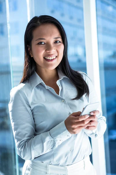 Smiling businesswoman using smartphone — Stock Photo, Image