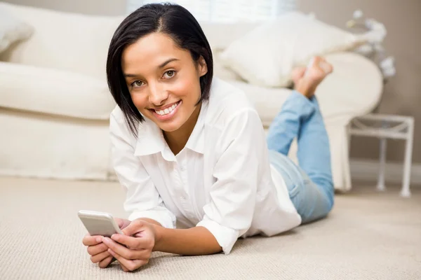 Lachende brunette met smartphone — Stockfoto