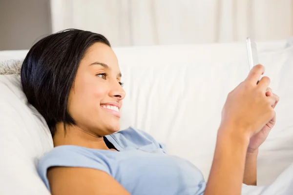Uśmiechający się brunetka korzystanie smartphone — Zdjęcie stockowe