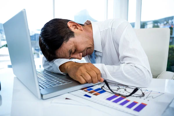Homme d'affaires épuisé dormant sur son ordinateur portable — Photo