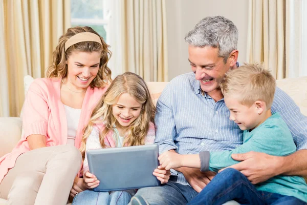 Famille utilisant une tablette sur le canapé — Photo