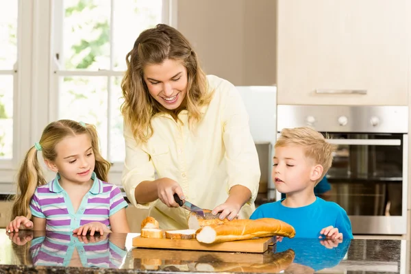 Glückliche Familie beim Brotschneiden — Stockfoto