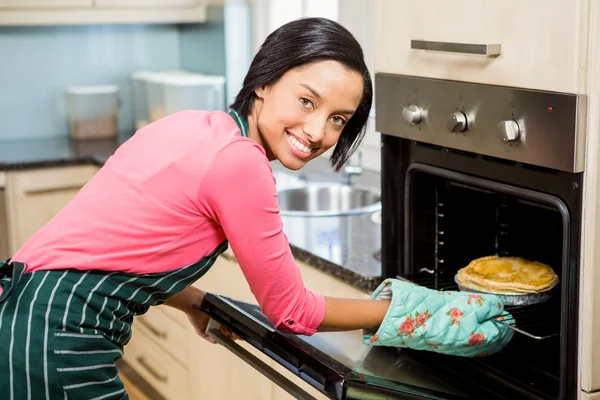Usmívající se žena pečení koláč — Stock fotografie