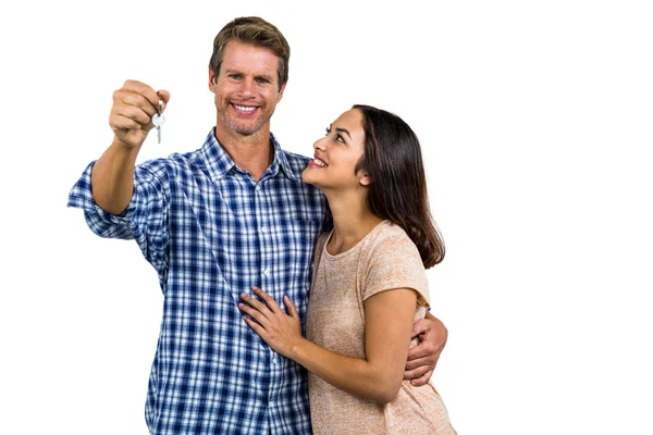 Casal feliz abraçando enquanto segurando as chaves de casa — Fotografia de Stock