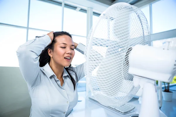 Femme d'affaires assise devant le ventilateur — Photo
