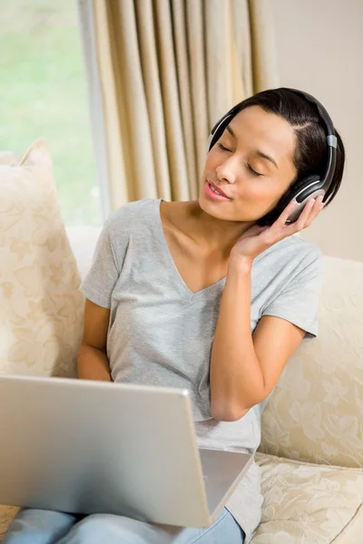 Morena usando portátil y auriculares —  Fotos de Stock