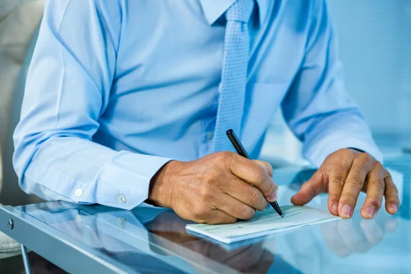 Geschäftsmann auf seinem Schreibtisch unterschreibt Dokument — Stockfoto