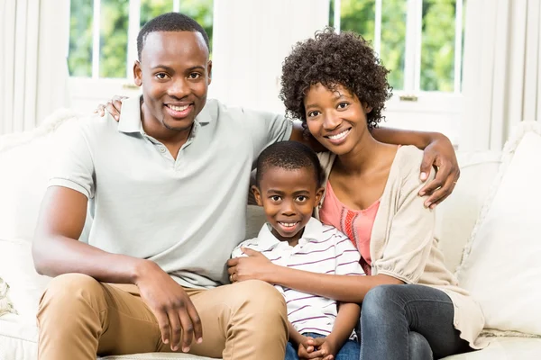 Família feliz sentada no sofá — Fotografia de Stock