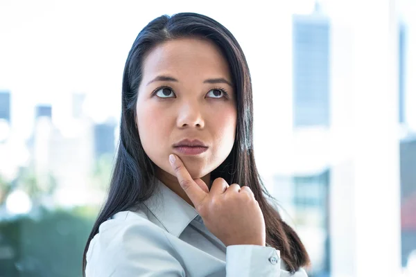 Pensativa mujer de negocios con el dedo en la barbilla —  Fotos de Stock