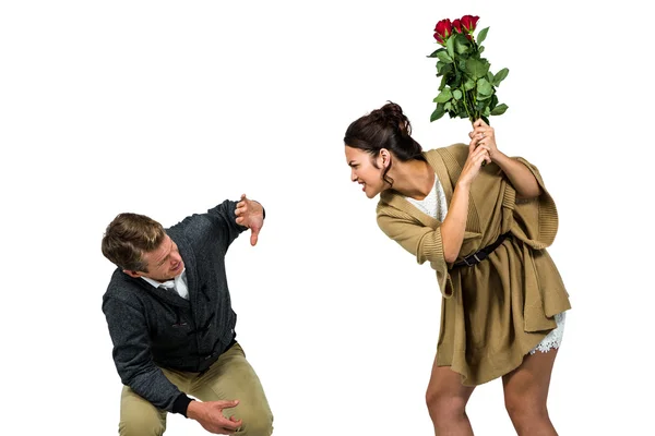 Frau schlägt Freund mit roten Blumen — Stockfoto