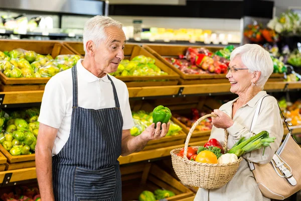 Senior klant en werknemer bespreken groenten — Stockfoto