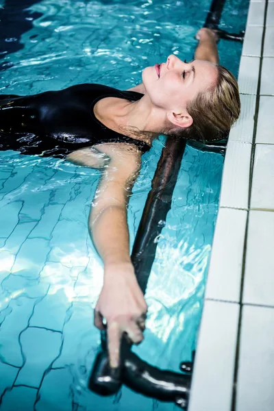 Mujer relajada flotando en la piscina — Foto de Stock