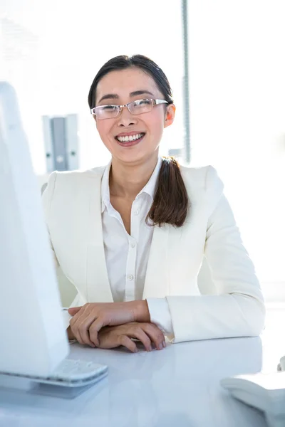 Mujer de negocios sonriente trabajando en su escritorio —  Fotos de Stock