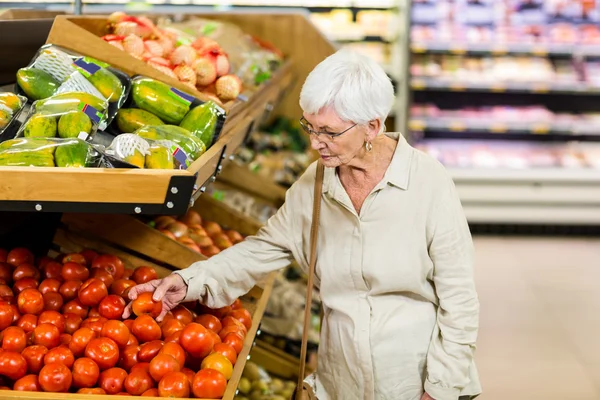 Senior vrouw kiezen haar tomaten — Stockfoto