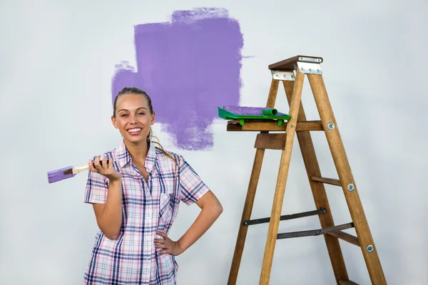 Mujer sonriente pintando una pared — Foto de Stock
