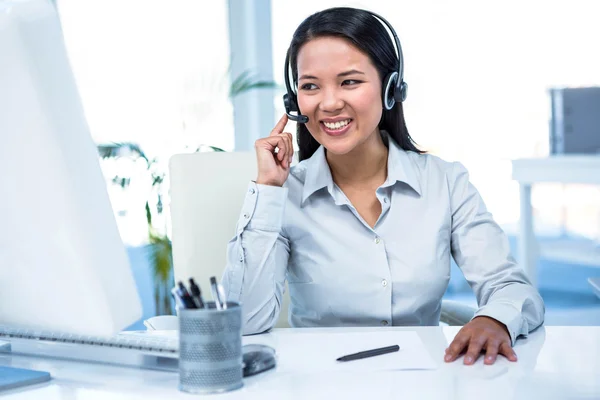 Mujer de negocios sonriente usando auriculares — Foto de Stock