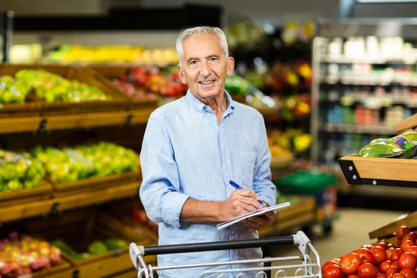 Hombre mayor sonriente con lista de supermercados — Foto de Stock