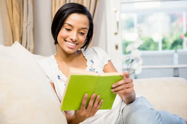 Smiling brunette reading a book Stock Image