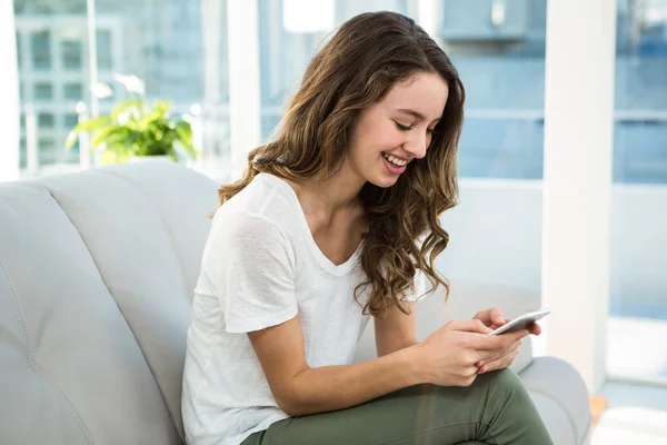 Mujer feliz mensajes de texto en el sofá —  Fotos de Stock