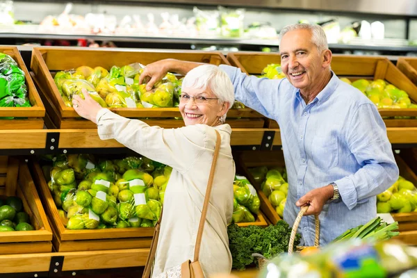 Sonriendo pareja de ancianos en la tienda de comestibles — Foto de Stock
