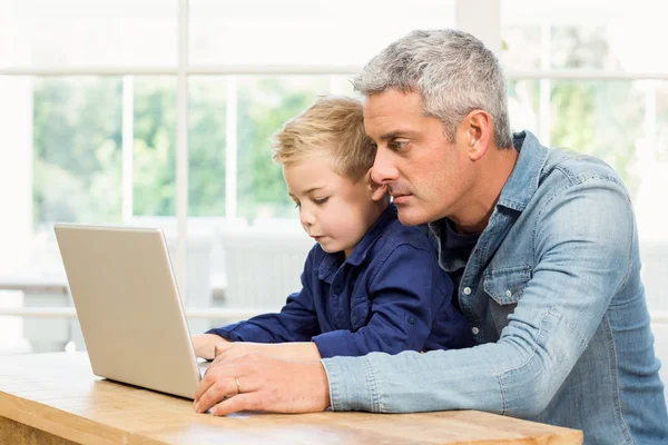 Pai e filho usando laptop — Fotografia de Stock