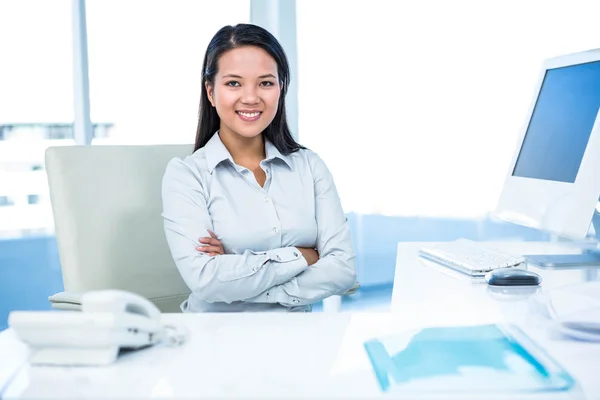 Smiling businesswoman with arms crossed looking at camera — Stock Photo, Image