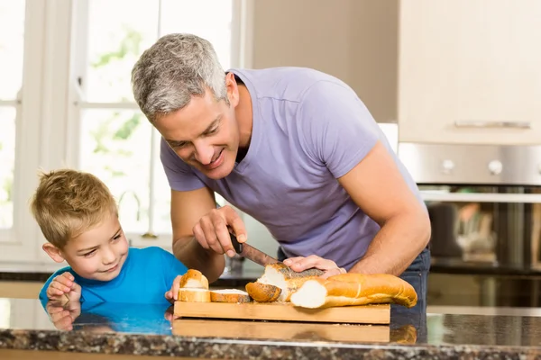 Happy father slicing bread — Stock Photo, Image