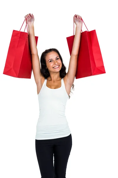 Mujer sonriente sosteniendo bolsas de compras rojas — Foto de Stock