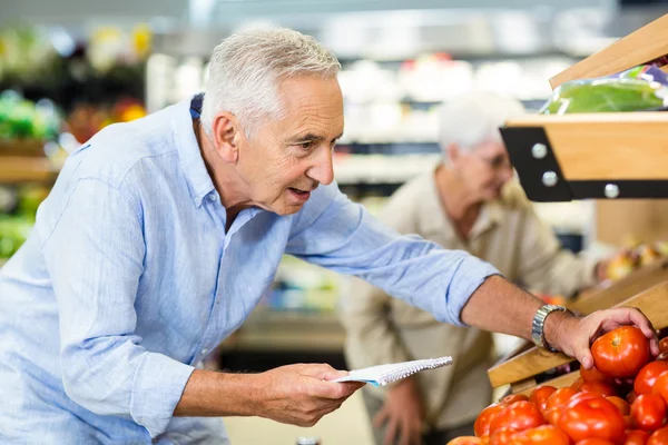 Glimlachend senior man met lijst kopen van apple — Stockfoto