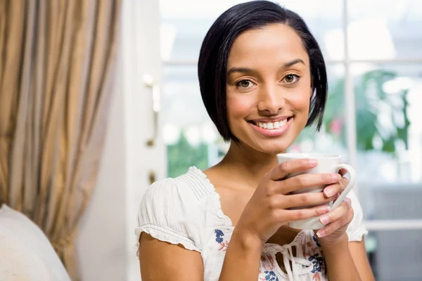 Sorrindo morena segurando copo branco — Fotografia de Stock