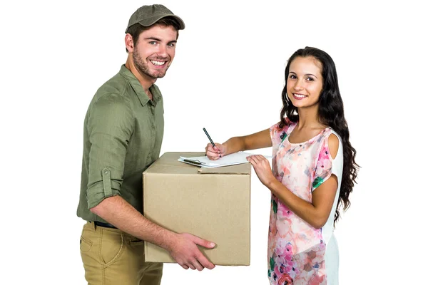 Vrouw ondertekening voor pack levering met lachende postbode — Stockfoto