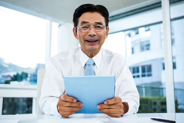 Smiling businessman using his tablet — Stock Photo, Image