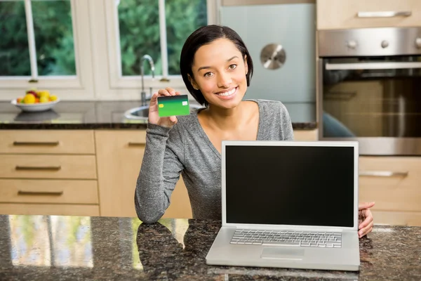 Morena mostrando laptop e cartão de crédito — Fotografia de Stock