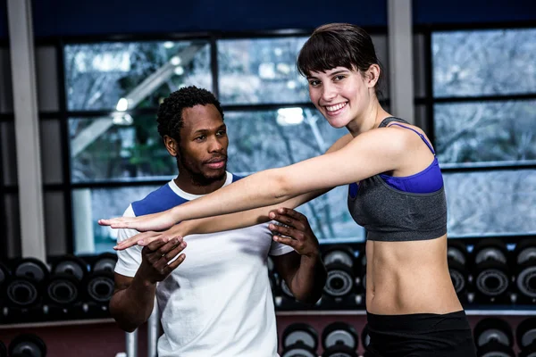 Treinador masculino ajudando mulher apto — Fotografia de Stock