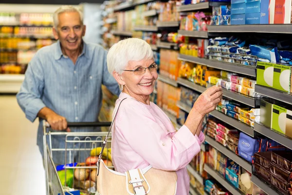 Woman takin picture of product on shelf — Stock Photo, Image