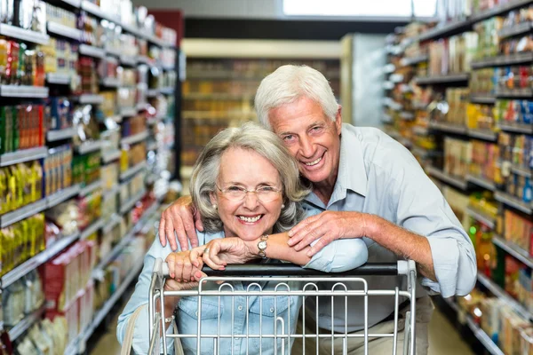 Happy senior couple with cart — Stock Photo, Image