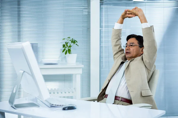 Businessman stretching his arms — Stock Photo, Image
