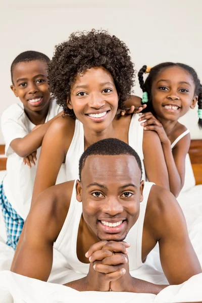 Familia feliz acostada en la cama juntos — Foto de Stock