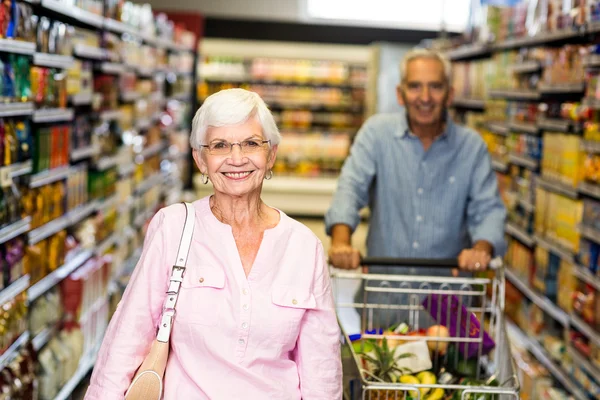 Woman smiling at camera in supermarket — Stock Photo, Image