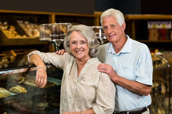 Smiling senior couple at the bakery store — Stock Photo, Image