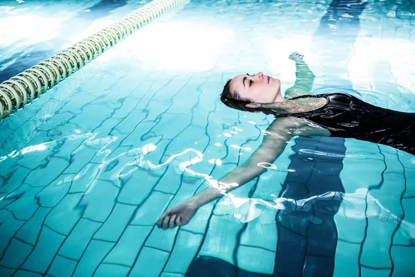 轻松的女人在游泳池中漂浮 — 图库照片