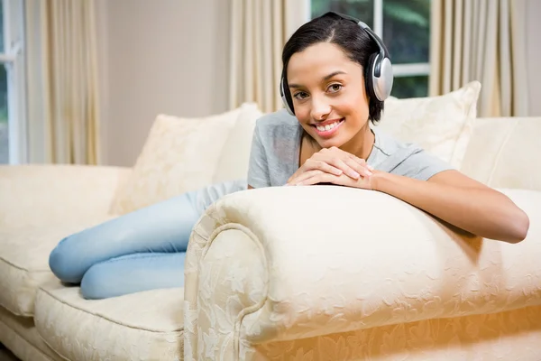 Brunette with headphones on sofa — Stock Photo, Image